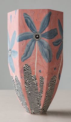 a pink vase with blue and black designs on it