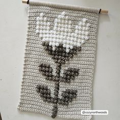 a crocheted wall hanging with flowers on it