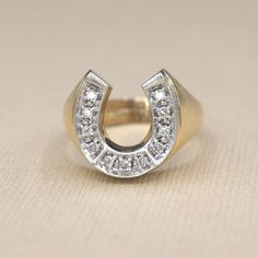 Vintage 14k gold horseshoe ring with approx .55 ctw of round brilliant cut diamonds. White gold topped to accentuate the diamonds. The sides of the band have a brushed finish.  Era: c.1970s Markings: 14k  Materials: 14k gold, .55 ctw diamonds  Ring Size: 8 (comes with free resizing by our jeweler) Weight: 7.1 grams Face measures 16mm x 14.85mm Rise: 4mm Condition: Excellent vintage condition with minor surface wear from age  Shipping is free in the United States Follow us on Instagram @LUXXORVin Diamond Horseshoe Ring For Anniversary, Horseshoe Diamond Ring For Anniversary, Classic Horseshoe Shaped Anniversary Rings, Horseshoe Ring, Diamonds Ring, Gold Top, Round Brilliant Cut Diamond, Gold Style, Diamond Bands