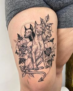 a woman's thigh with an image of two dogs and flowers on the side