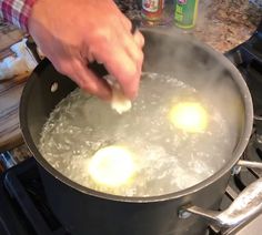 a person is frying eggs in a pan on the stove with water and oil