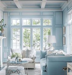 a living room with blue walls and white furniture