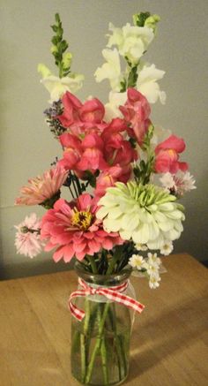 a vase filled with flowers on top of a wooden table