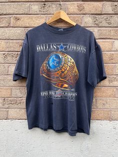 a t - shirt hanging on a brick wall that says, dallas cowboys super bowl champs