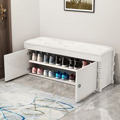 a white shoe storage bench with multiple pairs of shoes on it's bottom shelf