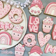 some decorated cookies are on a plate and next to the words love, love, and cupcakes