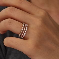 a woman's hand with three rings on her finger and one ring in the middle