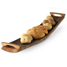 a wooden boat filled with bread on top of a white background