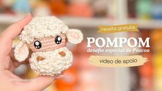 a hand holding a small crocheted sheep in front of a store shelf with the words pompom written below it