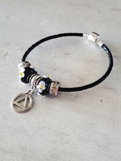 Fantastic, super fun (we are not a glum lot!) original one of a kind Pandora style charm bracelet with an AA symbol. Looks great on it's own or layered with other bracelets for the multiple strand trend. Sobriety is just one day at a time and sometimes it helps with a little shiny trinket on your wrist! - 7.5 inch black leather cord -Sterling silver barrel clasp -Pandora style -AA symbol -Nickel free -Celebrate sobriety (really, seriously, because you're a f%#king miracle) -Free shipping Recovery Bracelet, Aa Symbol, Recovery Gifts, Pandora Style, Charm Bracelets, Leather Band, Leather Cord, Bead Charms, Glass Beads