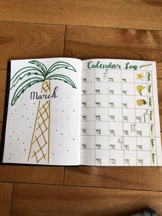 an open calendar book with palm trees on the pages and numbers in each page, sitting on a wooden floor