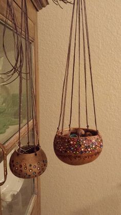 two hanging planters filled with plants in front of a window