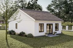 a small white house sitting on top of a lush green field