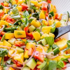 a salad in a white bowl with a wooden spoon on the side, ready to be eaten