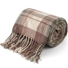 a brown and white plaid blanket with fringes on the bottom, laying on top of it