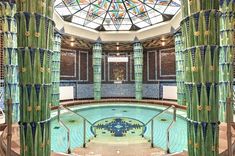 an indoor swimming pool surrounded by green curtains