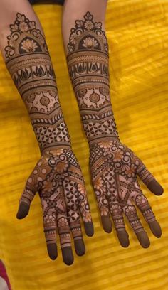 two hands with henna tattoos on them