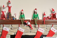 the elfs are hanging on the mantle with their stockings