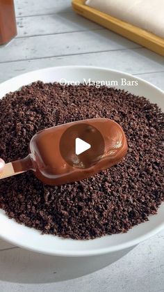 a spoon filled with chocolate on top of a white plate