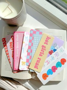 a stack of books sitting on top of a window sill next to a cup