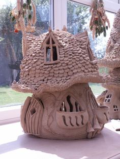 a clay model of a house on display in front of a window