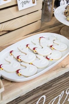 some cookies are on a white platter with red and yellow decorations in the shape of turkeys