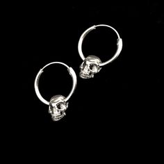 Sterling silver hoop earring has a diameter of 7/8 inch with a .75 inch , hollow , silver plated pewter skull hanging from it. It latches by fitting the wire section back into the hollow hoop. The hoop is 7/8 inch x 2mm thick. The combined pieces measure 1.25 inches. These earrings are SOLD PER PAIR. This piece of jewelry is sent in a bubble pack envelope via US postal service, first class mail,free in the US. International rate is $15. Buyers are responsible for any customs and import taxes tha Adjustable Edgy Sterling Silver Jewelry, Edgy Adjustable Jewelry For Everyday, Edgy Silver Jewelry For Everyday, Gothic Single Stainless Steel Earring, Edgy Sterling Silver Jewelry In Silver, Edgy Sterling Silver Jewelry For Everyday, Silver Sterling Silver Jewelry For Streetwear, Minimalist Metal Jewelry For Streetwear, Edgy Everyday Sterling Silver Jewelry