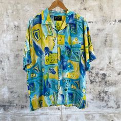 "Vintage abstract floral silk shirt Fits Size XL -Chest: 26\" (pit to pit) -Length: 30\" (top of shoulder to bottom hem) -Sleeve: 10.5\" -Shoulders: 22.5\" In good vintage condition" Summer Silk Shirt With Graphic Print, Blue Floral Print Top With Camp Collar, Casual Silk Tops With Vibrant Print, Spring Hawaiian Shirt With Abstract Print, Silk Summer Tops With Graphic Print, Silk Graphic Print Top For Summer, Silk Top With Graphic Print For Summer, Casual Spring Shirt With Abstract Pattern, Summer Silk Shirt With Floral Print