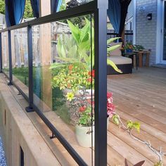 a glass balcony with plants and flowers on it