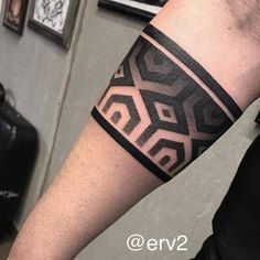 a man with a black and white tattoo on his arm that has an abstract design