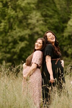 two women standing in tall grass with their arms around each other