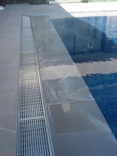 a metal grate sitting on the side of a swimming pool