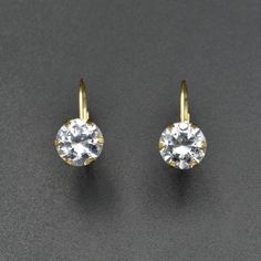 Get the diamond look for way less! Two 14 karat gold earring settings are the showcase for a large and lovely pair of cubic zirconia or CZ, a popular diamond simulant. Earrings are comfortable and secure to wear due to the leverback design.  More details: CZs measure 8.0mm across, earrings measure 16.7mm in total length Excellent condition 14k (stamped) 2.5 grams All purchases arrive in a gift box, wrapped with a ribbon. Formal Yellow Gold Crystal Earrings For Pierced Ears, Classic Diamond White Crystal Earrings, Classic Crystal Earrings For Anniversary With Lever Back, Classic Round Cut Crystal Earrings, Classic Cubic Zirconia Crystal Earrings For Anniversary, Classic Gold Crystal Earrings With Cubic Zirconia, Classic Anniversary Cubic Zirconia Crystal Earrings, Classic Diamond Crystal Earrings, Classic Round Crystal Earrings With Lever Back