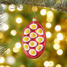 an ornament hanging from a christmas tree decorated with boiled eggs and cheeses