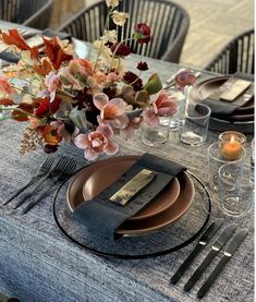 a table set with place settings and flowers