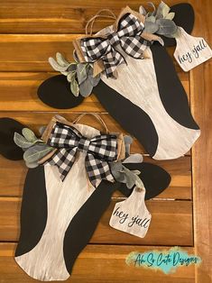 two black and white cow heads with tags attached to them on a wooden table top