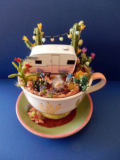 a cup filled with flowers and plants on top of a saucer