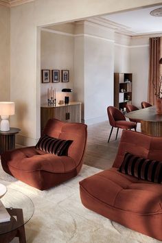 a living room filled with furniture next to a dining room table and chairs in front of a window