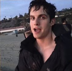 a young man making a funny face on the beach