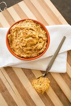 a bowl filled with food sitting on top of a wooden cutting board next to a knife