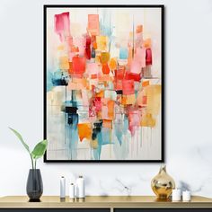 an abstract painting hangs on the wall next to a table with candles and vases