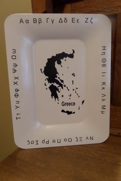 a white plate with an image of the greek island of greece in black on it