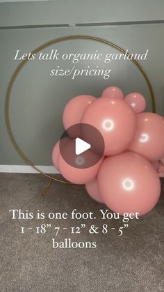 a bunch of pink balloons sitting on top of a floor next to a round object