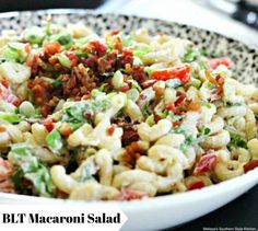 a white bowl filled with pasta salad on top of a table