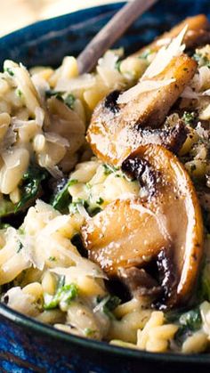 a blue bowl filled with pasta and mushrooms