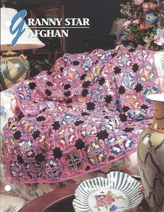 the crochet granny blanket is on display in front of a vase and other items