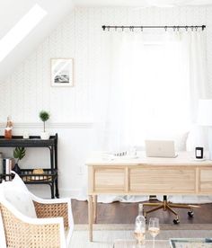 a room with a desk, chair and computer on the table in front of a window