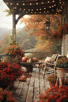 the porch is decked out with pumpkins and flowers