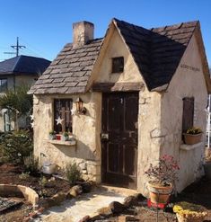 a small stone house with a black roof