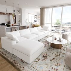 a living room filled with white furniture next to a kitchen and dining room table on top of a rug